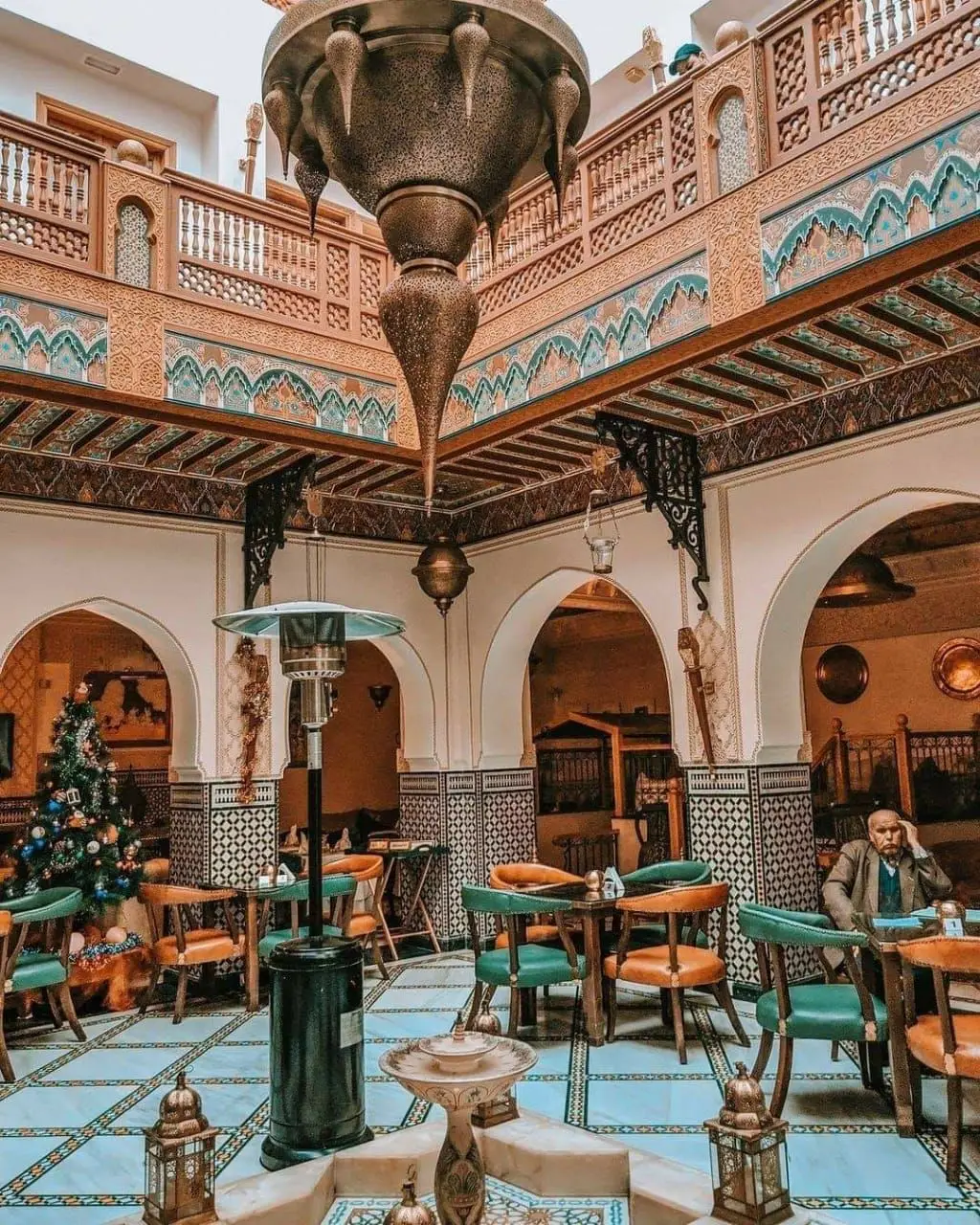 Interior of a traditional Moroccan cafe with colorful tiles, arches and lanterns