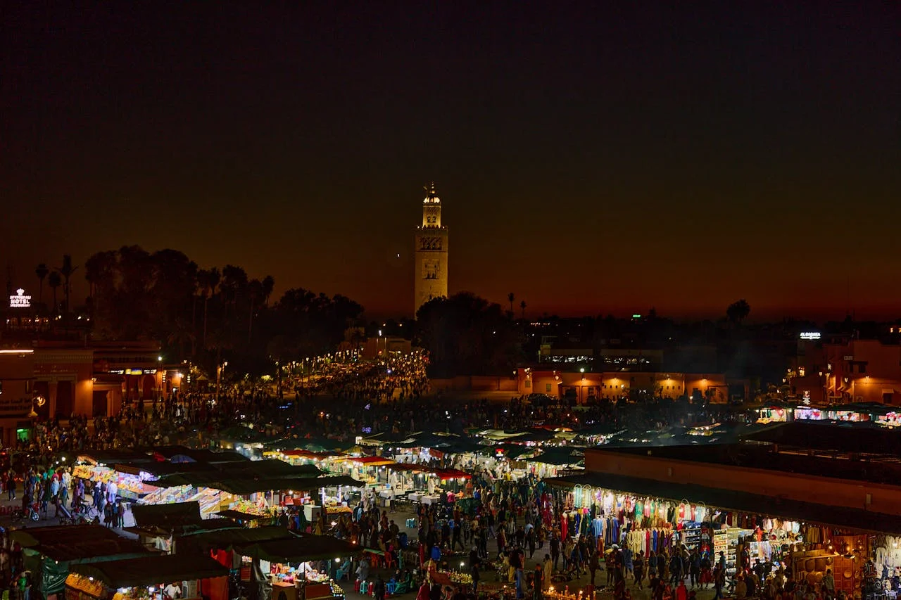 Night scene at Jemaa el-Fnaa with illuminated food stalls and crowds of visitors