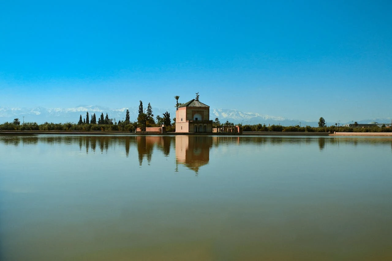 Peaceful Menara Gardens with reflective pool and Atlas Mountains in the background at golden hour