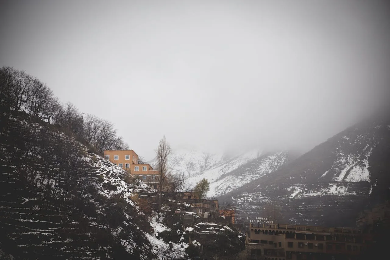 Trekkers walking through Imlil valley with Mount Toubkal and traditional Berber stone villages visible above