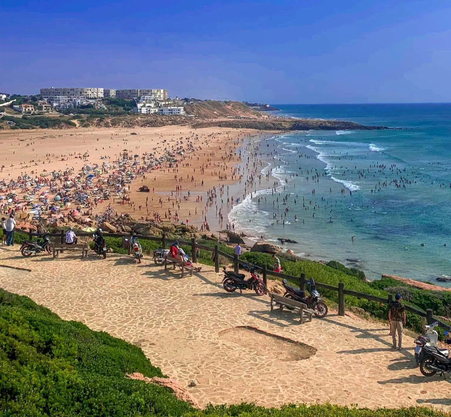 The pristine shoreline of Achakkar Beach with golden sand and clear blue Mediterranean waters